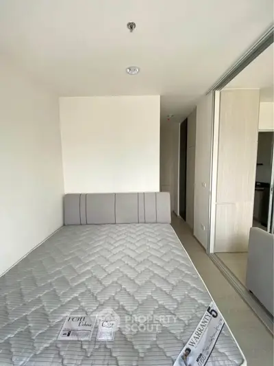 Modern bedroom with minimalist design and sliding door wardrobe in a bright apartment.