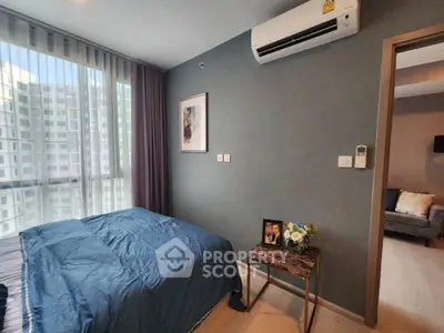 Modern bedroom with large windows offering ample natural light, complemented by elegant dark walls and air conditioning for comfort.