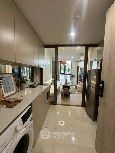Modern kitchen with sleek appliances and open view to stylish living room