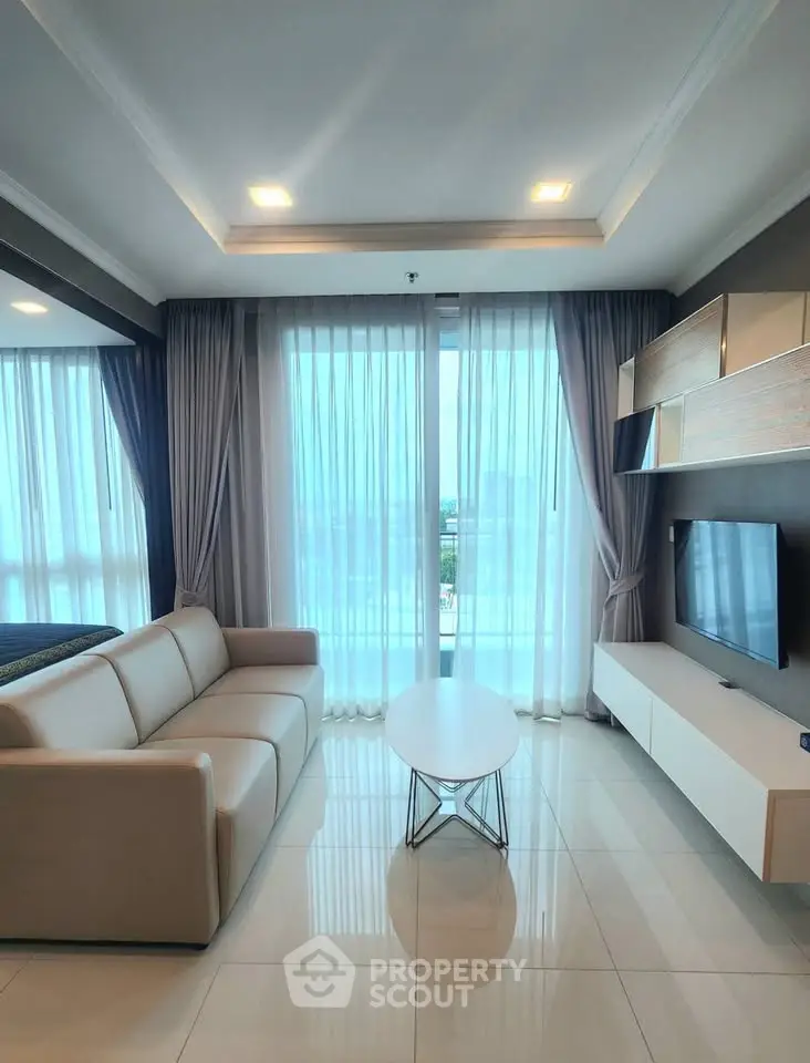 Modern living room with sleek furniture and large windows offering a stunning view.