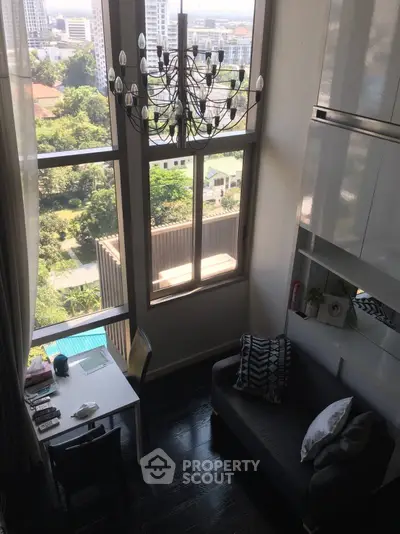 Stunning high-ceiling living room with large windows and city view, featuring elegant chandelier and modern decor.