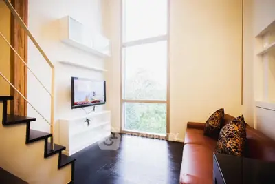 Spacious living room with high ceilings and large windows offering a stunning view.