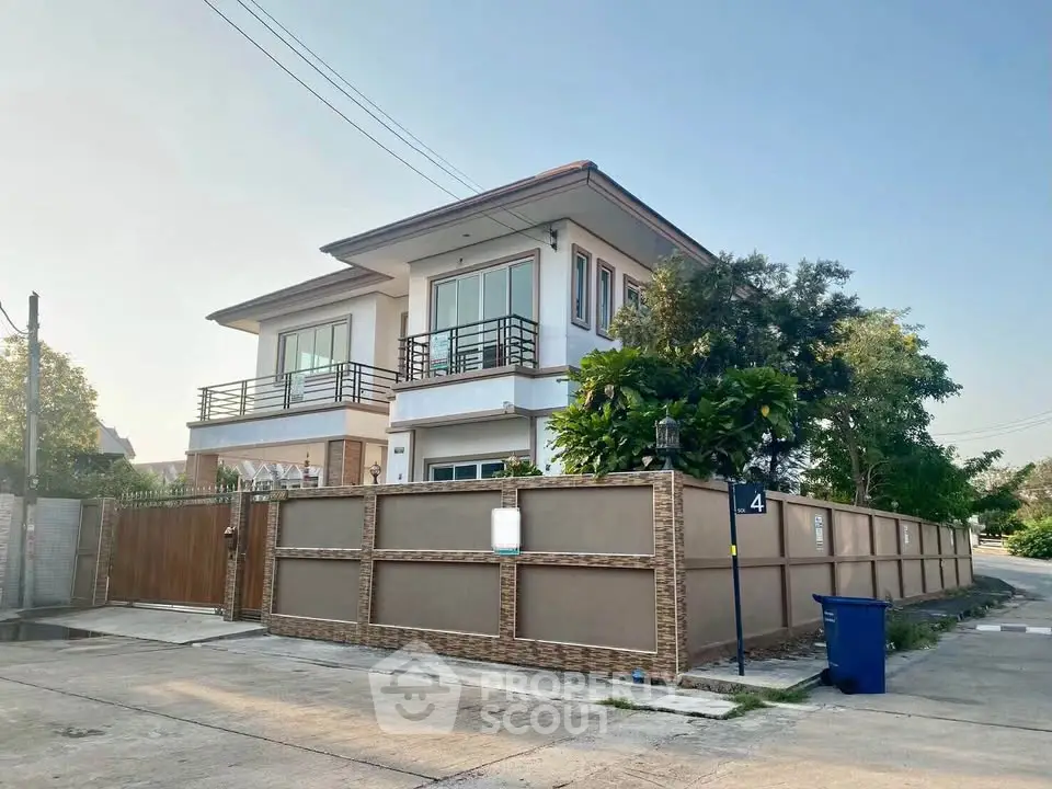 Modern two-story house with spacious balcony and fenced yard in a serene neighborhood.