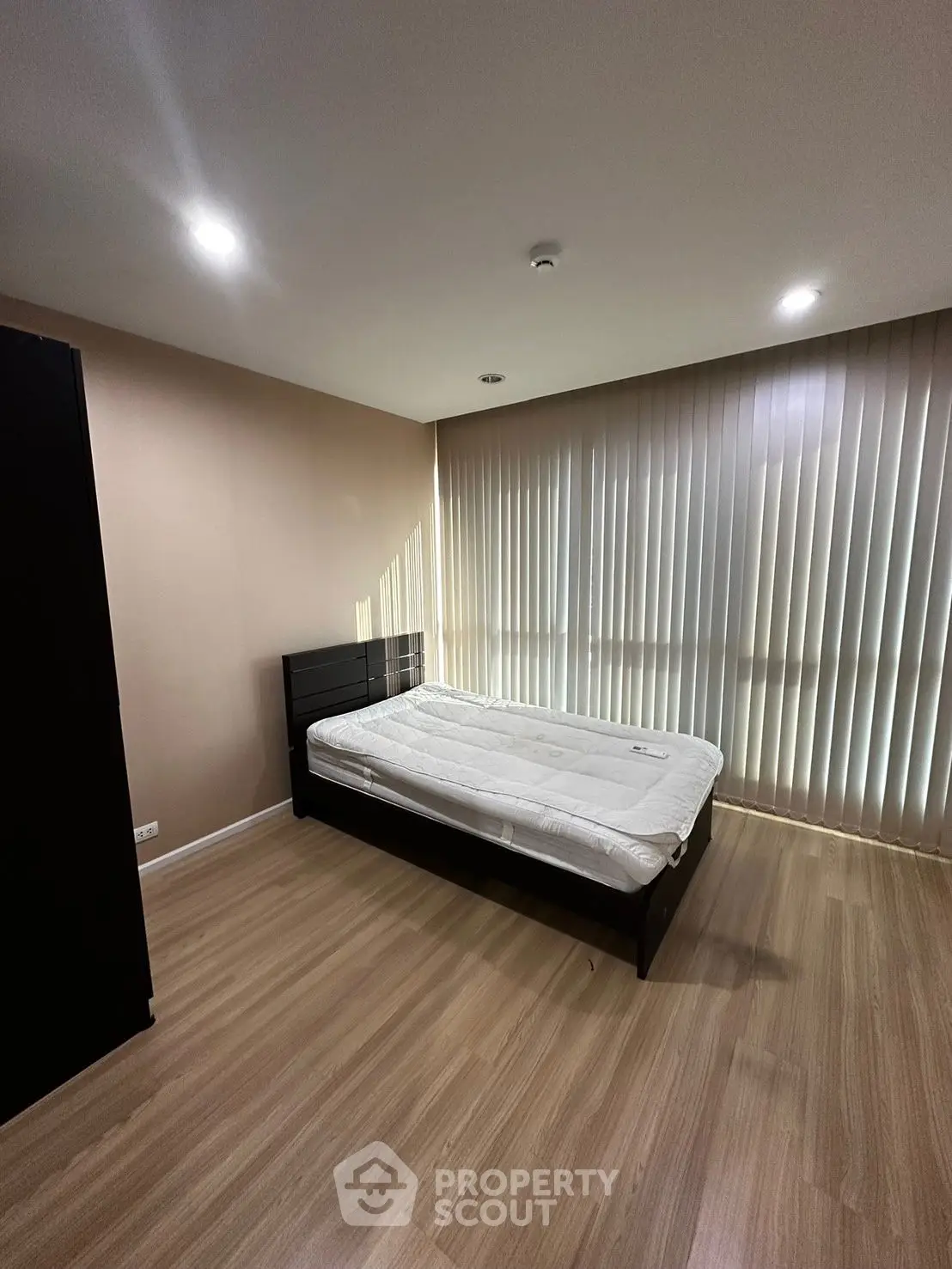 Modern bedroom with sleek design and natural light, featuring a comfortable bed and stylish flooring.