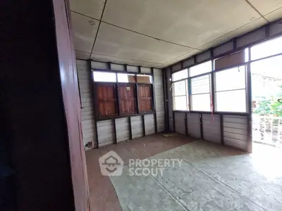 Spacious room with large windows and wooden flooring, ideal for customization.