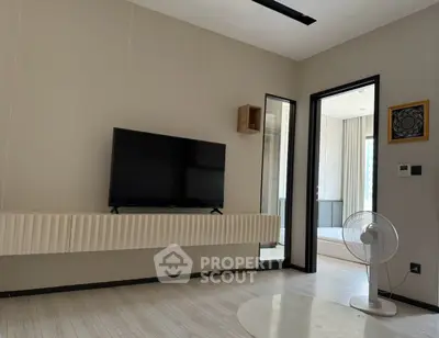 Modern living room with wall-mounted TV and sleek fan, showcasing minimalist design.