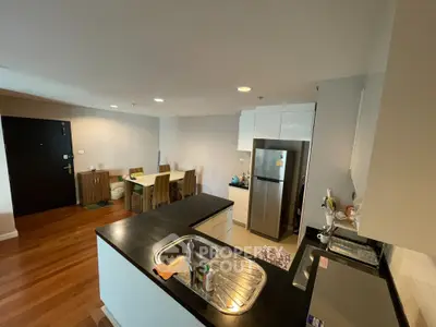 Modern open-layout kitchen with sleek countertops and dining area in stylish apartment