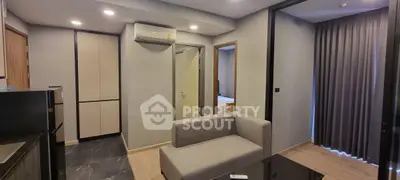 Modern living room with sleek design and neutral tones, featuring a comfortable sofa and air conditioning.