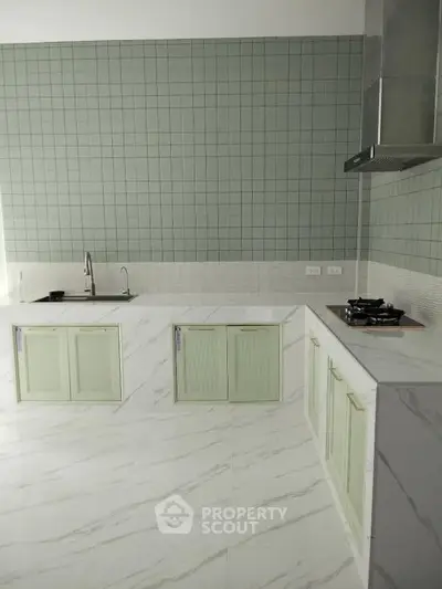 Modern kitchen with sleek marble countertops and gas stove