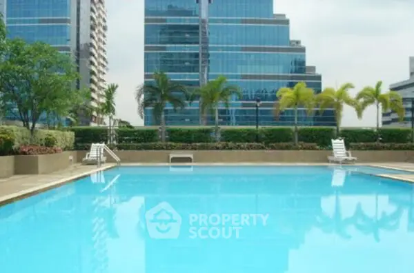 Luxurious outdoor pool with modern high-rise buildings in the background, perfect for relaxation and leisure.