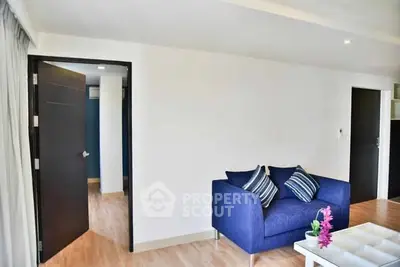 Modern living room with blue sofa and wooden flooring