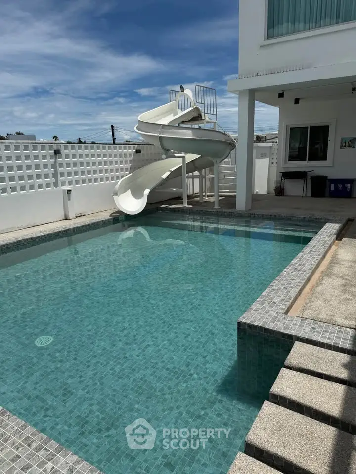Luxurious private pool with slide in modern villa, perfect for family fun and relaxation.