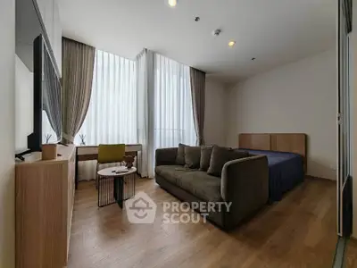 Modern studio apartment with cozy living area and large windows