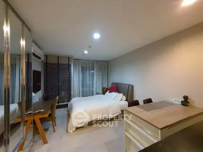 Modern bedroom with sleek design, featuring a cozy bed, mirrored wardrobe, and stylish workspace.
