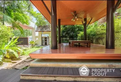 Stunning garden gazebo with wooden deck and lush greenery, perfect for relaxation and outdoor gatherings.