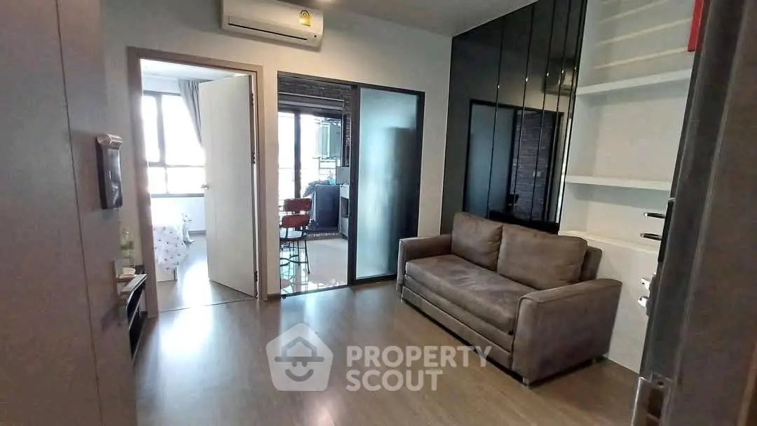 Modern living room with sleek design and natural light, featuring a comfortable sofa and stylish flooring.
