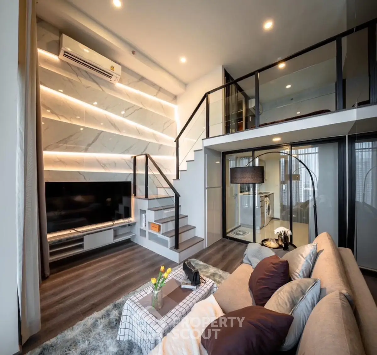 Modern loft-style living room with elegant staircase and cozy seating area