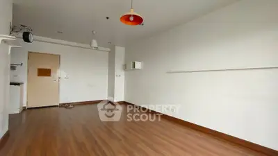 Spacious empty room with wooden flooring and modern lighting, ideal for customization.