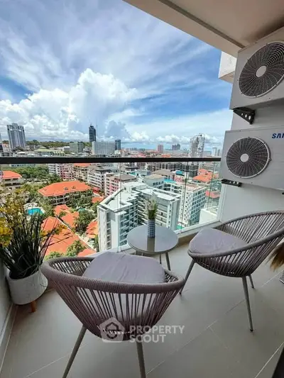 Stunning balcony view with modern seating overlooking city skyline and lush greenery.