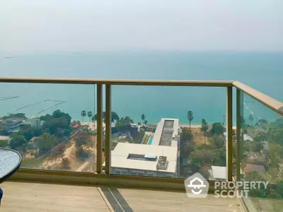 Stunning ocean view from high-rise balcony with glass railing and serene surroundings.