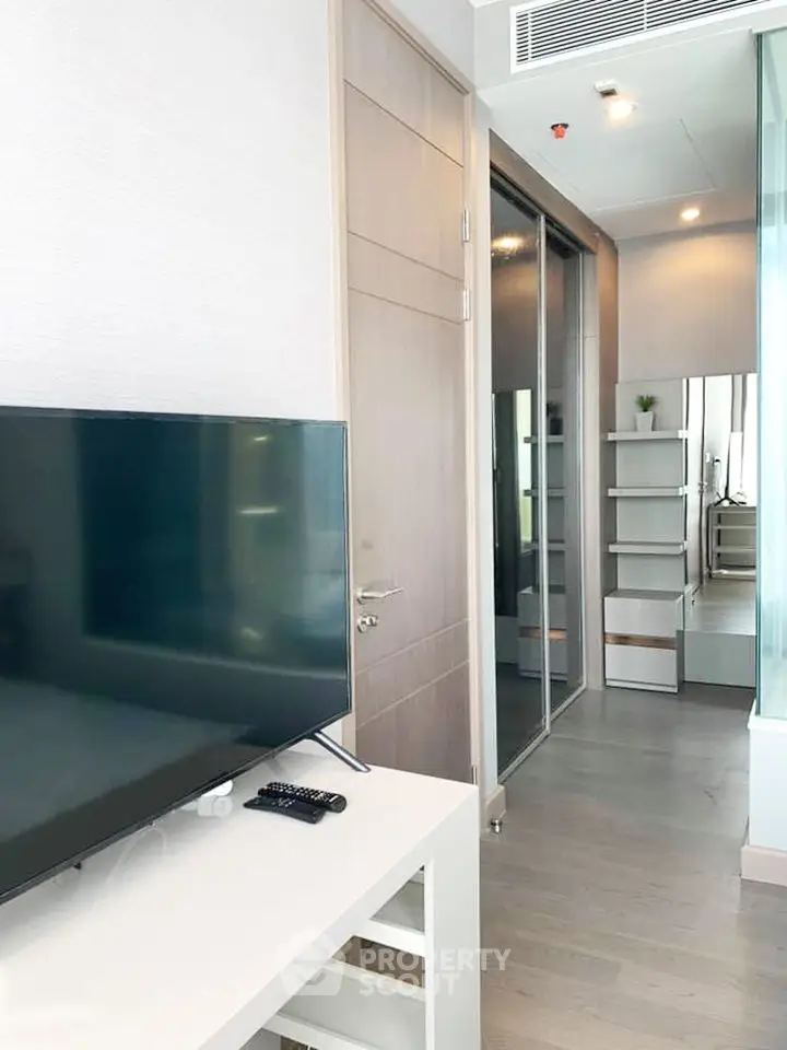 Modern apartment interior with sleek TV setup and stylish storage solutions.