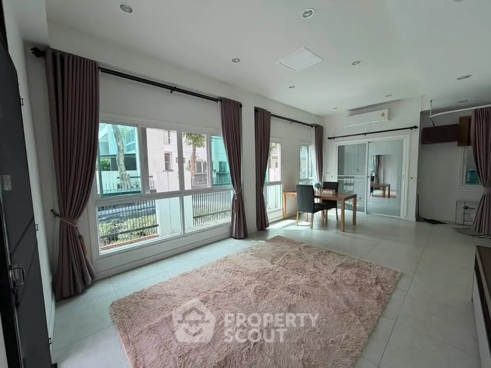 Spacious living room with large windows and plush carpet in modern home