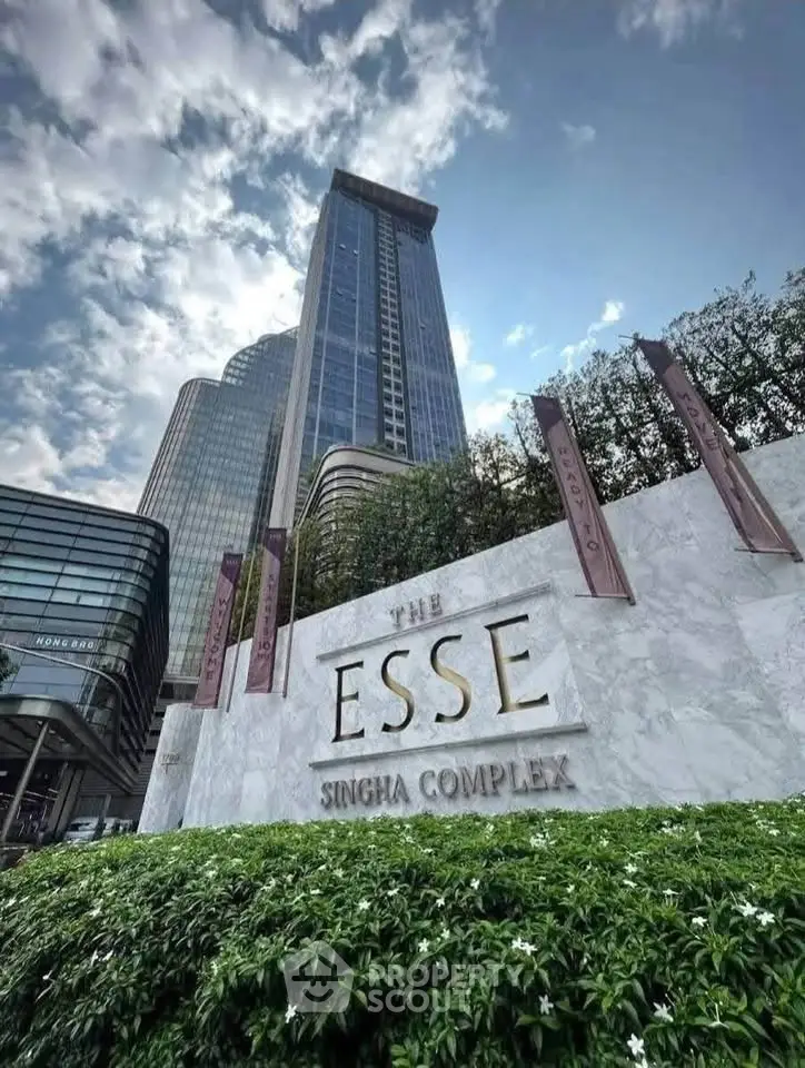 Luxurious high-rise building at The Esse Singha Complex with modern architecture and lush greenery.