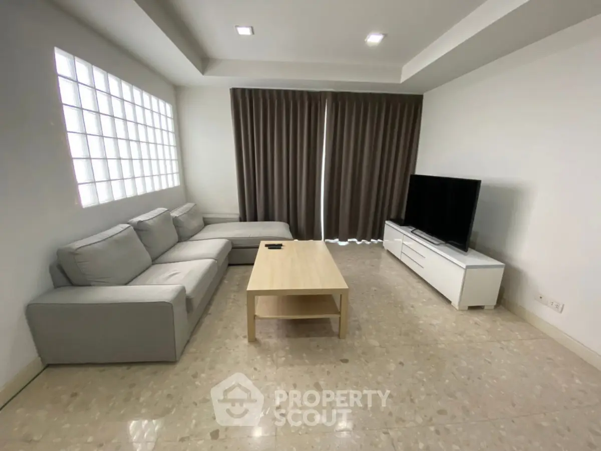 Modern living room with sleek furniture and large TV, perfect for relaxation and entertainment.