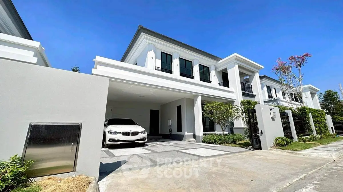 Modern luxury house with sleek design and spacious driveway in sunny neighborhood.