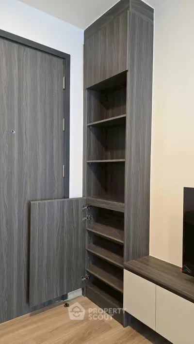 Modern interior with sleek wooden storage unit and door, showcasing minimalist design.