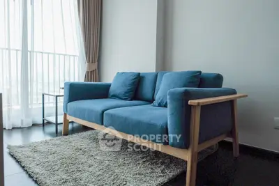 Modern living room with stylish blue sofa and large window view