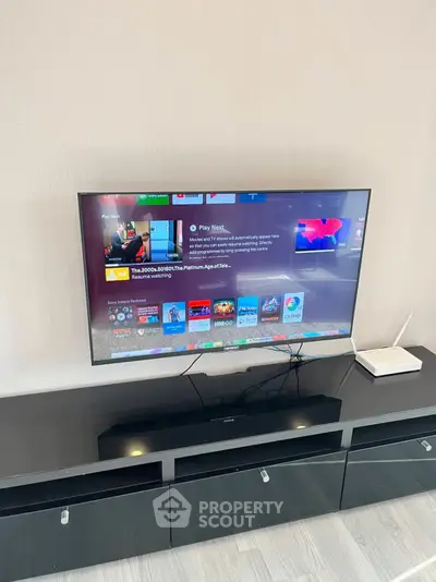 Modern living room with sleek black TV stand and mounted flat-screen TV
