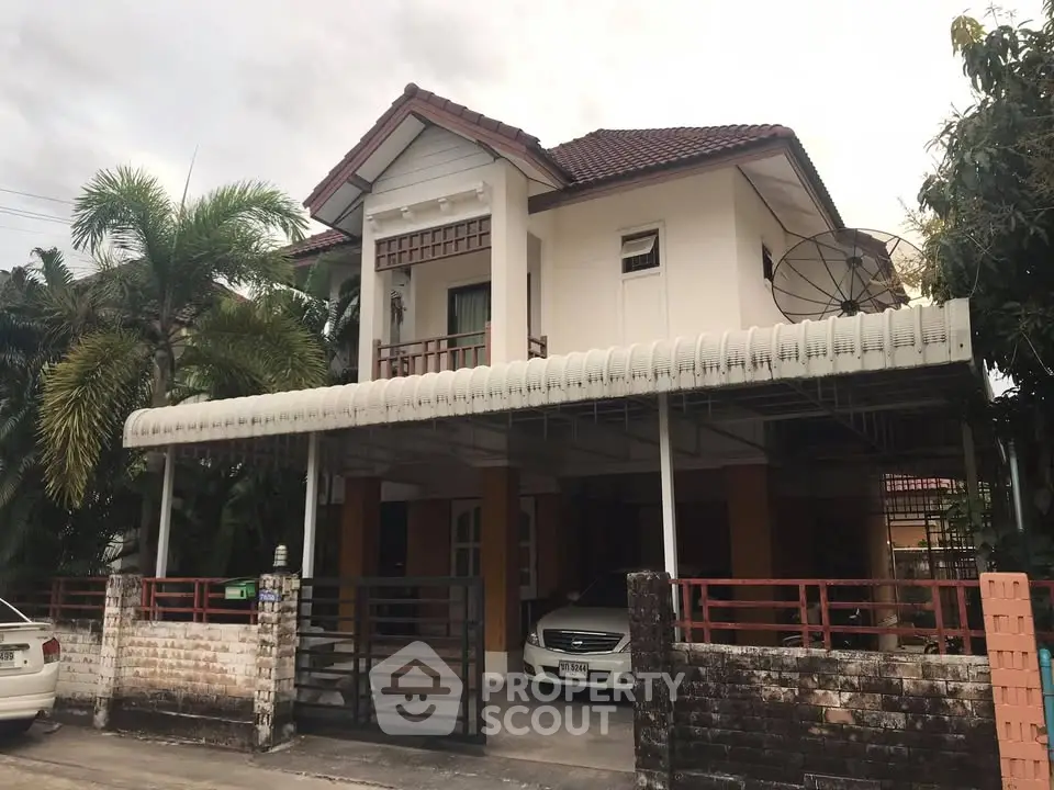 Charming two-story house with carport and lush greenery in suburban setting.