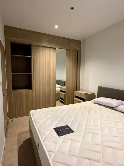 Modern bedroom with wooden wardrobe and comfortable mattress in a stylish apartment.