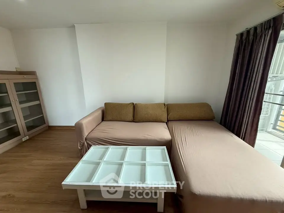 Spacious living room with modern sofa and glass coffee table, perfect for relaxation and entertaining.