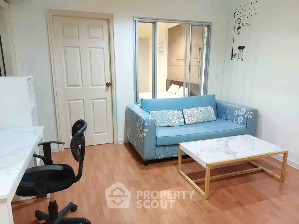 Charming living room with stylish blue sofa and modern decor, perfect for cozy relaxation.