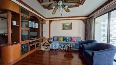 Spacious living room with elegant wooden decor and large windows for natural light.