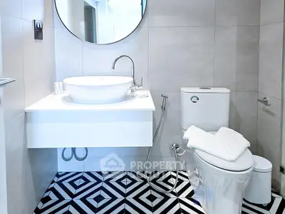 Modern bathroom with stylish geometric floor tiles and sleek fixtures.
