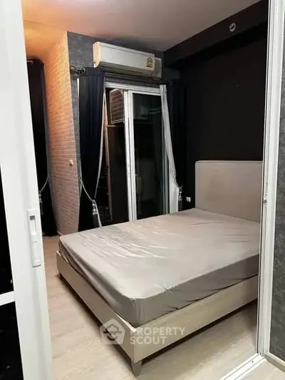 Modern bedroom with sleek design and balcony access in urban apartment