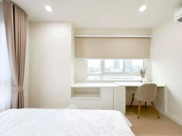 Bright and modern bedroom with study area and large window view.