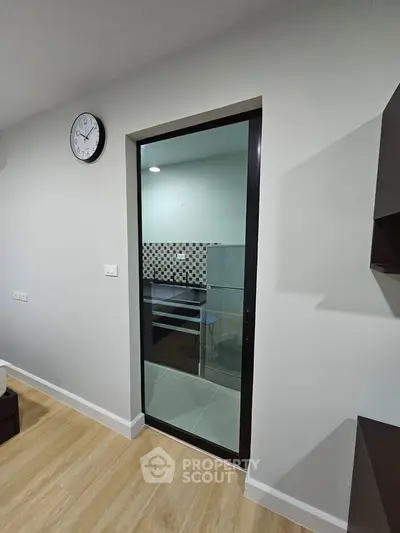 Modern kitchen with glass door and stylish backsplash in a cozy apartment.