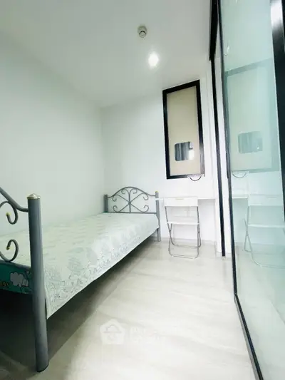 Cozy minimalist bedroom with single bed and study desk, perfect for students or professionals.