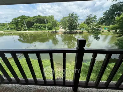 Charming balcony view overlooking serene pond and lush greenery, perfect for relaxation and nature lovers.