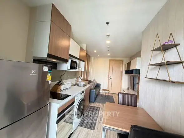 Modern kitchen with sleek appliances and dining area in a stylish apartment.