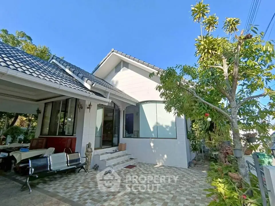 Charming suburban house with tiled patio and lush greenery