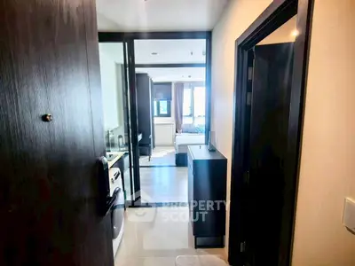 Modern apartment entrance leading to a cozy bedroom with stylish decor and natural light.