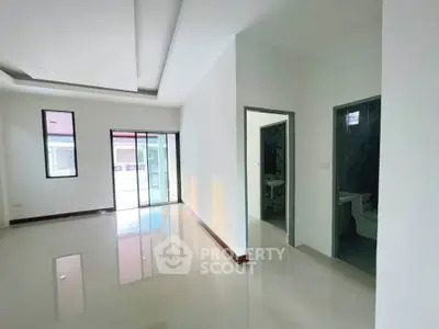 Spacious modern living room with glossy floors and large windows for natural light.