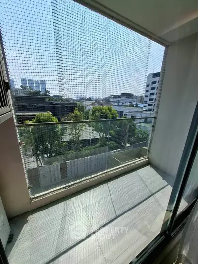 Spacious balcony with city view and safety netting in modern apartment