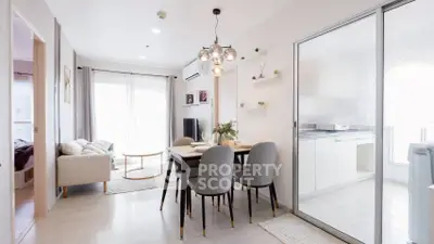 Modern dining area with elegant lighting and open kitchen layout in a bright apartment.