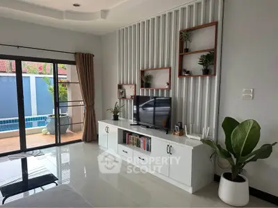 Modern living room with pool view, stylish decor, and natural light
